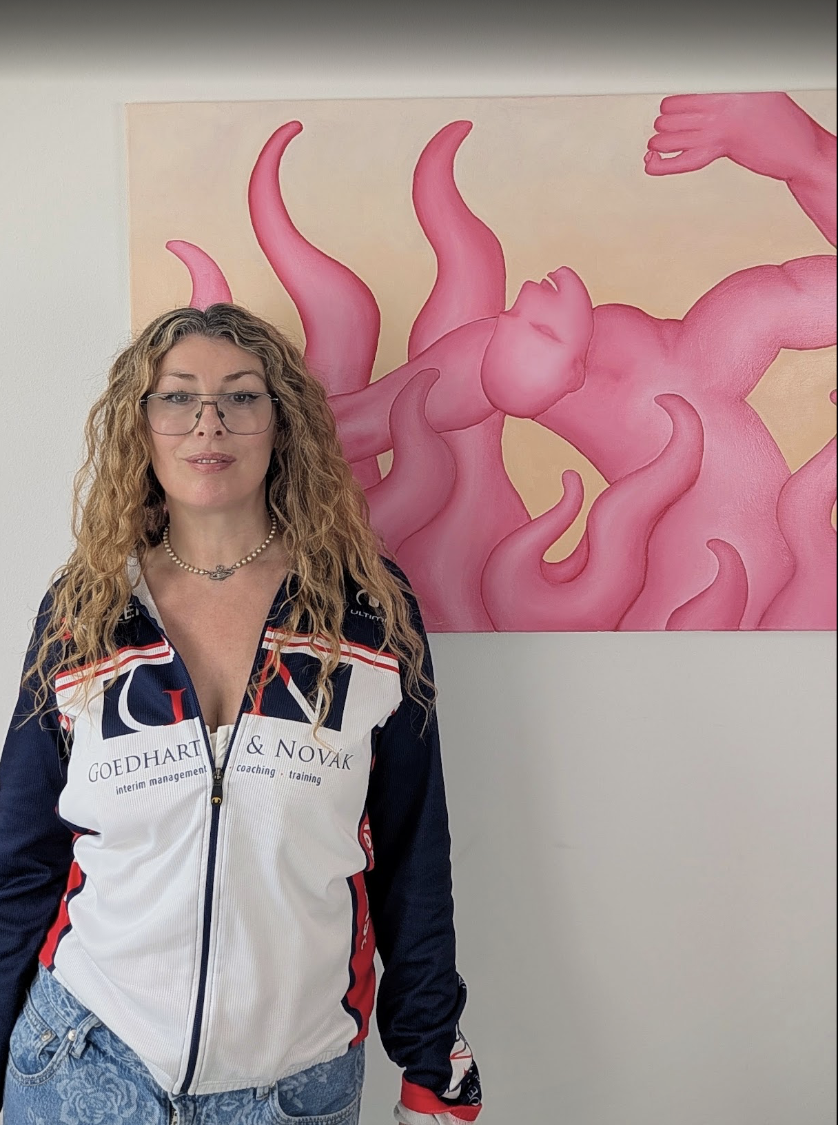 Portrait of Keda Breeze standing in front of a large pink figurative painting